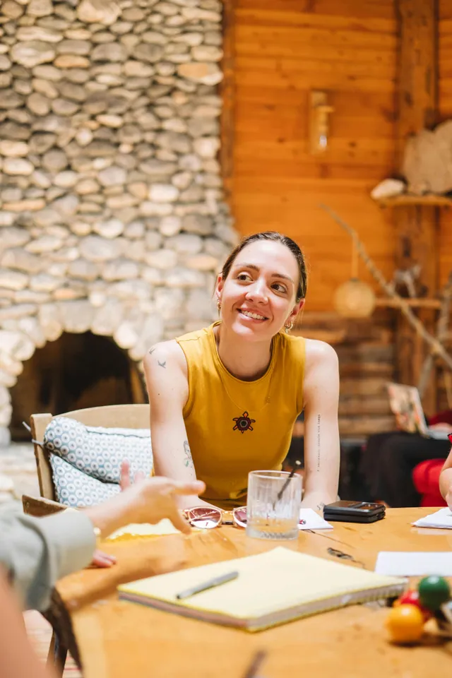 Mujer sentada en una mesa sonriendo